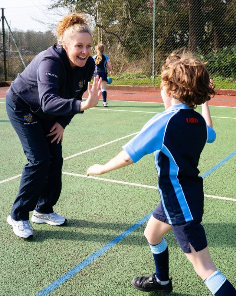 Director of Sport at Rugby School Debbie Skene at Old Buckenham Hall School (OBH) Director of Sport at Rugby School Debbie Skene high-fiving an OBH pupil during a netball session, representing the boarding pathway partnership from OBH to Rugby School.